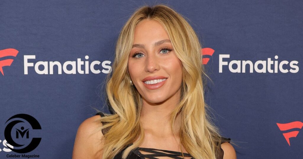Alix Earle smiling at a Fanatics event wearing a black dress with her signature blonde hair and blue eyes