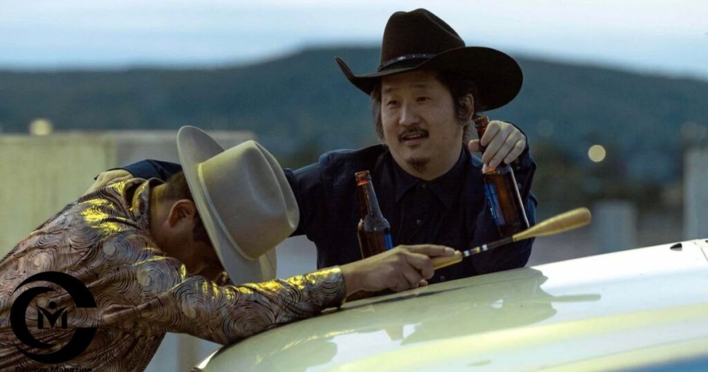 Bobby Lee wearing a black cowboy hat holding a beer bottle