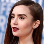 Lily Collins at a red carpet event, showcasing her elegant look and signature bold eyebrows.